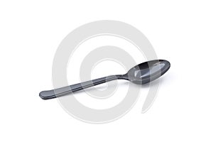 Single small black plastic baby teaspoon isolated from white background