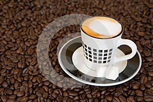 Single small coffee cup on coffee beans background