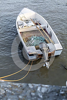 A single, small motor boat, moored in a harbor