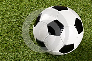 Single soccer ball on green grass lawn background with copy space