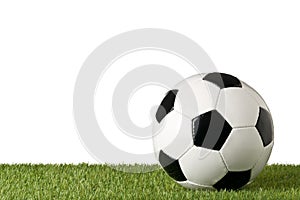 Single soccer ball on green grass lawn background over white background