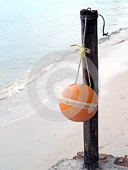 single sphere mooring buoy or fishing tool hanging on bamboo wooden pole of corner pier