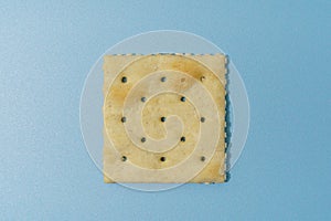 Single Square Saltine Cracker On Blue Background