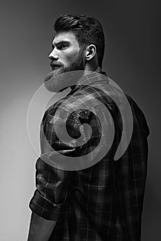 Single standing in profile young handsome serious bearded man