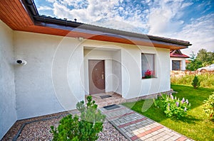 Single storey private house wide angle image, hdr colors, outside view with garden in summer