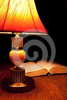Single table-lamp and opened book