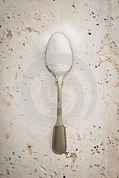 A single teaspoon with white sugar