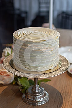 Single tier wedding cake decorated in butter cream ruffles.