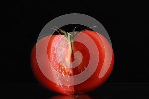 Single tomato isolated on black background