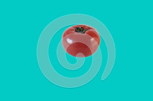 Single tomato subject with cyan background photo