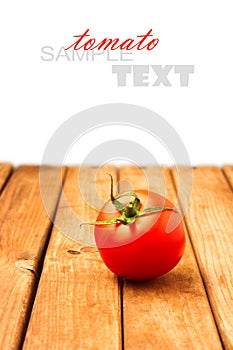 Single tomato on wooden table