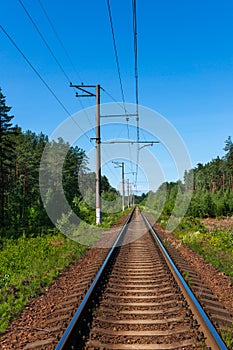 Single track railway line on a clear sunny day. Perspective view