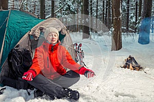 Single trekking in the winter forest, girl doing yoga