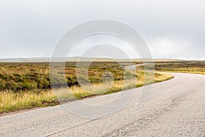 Single twisty, wavy, serpentine road with mist above in North Coast 500, Scotland