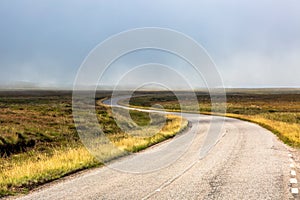 Single twisty, wavy, serpentine road with mist above in North Coast 500, Scotland