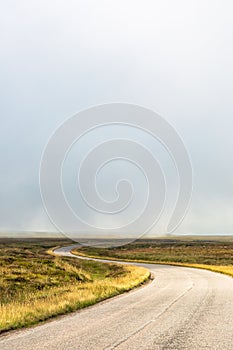 Single twisty, wavy, serpentine road with mist above in North Coast 500, Scotland