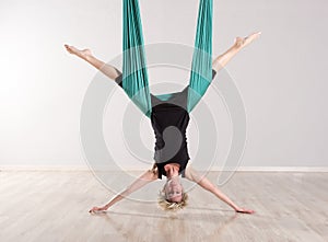 Single upside down woman doing aerial yoga splits