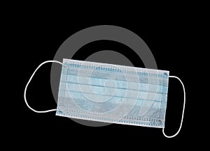 Single use Covid19 use surgical mask isolated on black with copyspace for your comment.