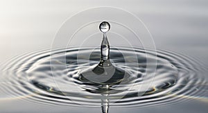 Single water droplet creating ripple effect on calm surface macro view
