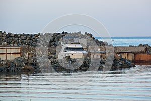 Single white boat near the stone pier.