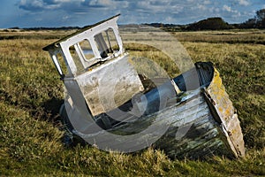 Single white rowing boat stuck on mud flats