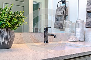 Single white sink with black faucet built on the countertop of bathroom vanity