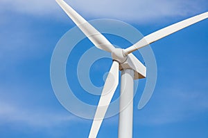 Single White Wind Turbine Over Dramatic Blue Sky