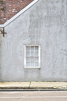 Single white window on gray stucco background