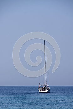 Single white yacht with furled sail