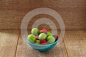 Single whole fresh green Can Erik plum and cherry close up isolated on dark background.