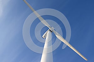 Single wind turbine against blue sky