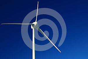 Single wind turbine on dark blue sky