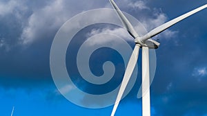 Single wind turbine set against a dark cloudy sky