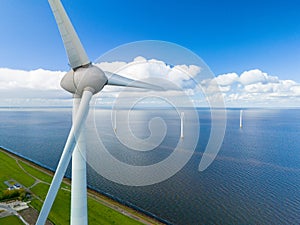 A single wind turbine towers over the ocean, its blades spinning gracefully in the wind, harnessing the power of nature photo