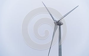 Single wind turbine on a winters / foggy day with white background