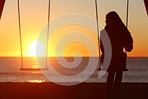 Single woman alone swinging on the beach