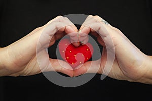 Single woman holding a red felted heart looking for love