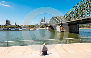 Single woman pending the time at the deutzer rhine boulevard at a summer day in Cologne