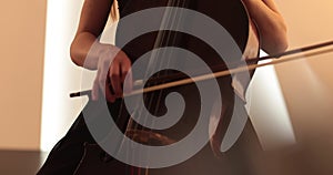 Single woman playing the cello, close-up and medium close-up, cello bow and strings