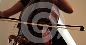 Single woman playing the cello, close-up and medium close-up, cello bow and strings