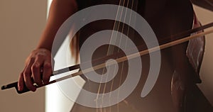 Single woman playing the cello, close-up and medium close-up, cello bow and strings