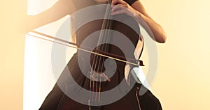 Single woman playing the cello, close-up and medium close-up, cello bow and strings