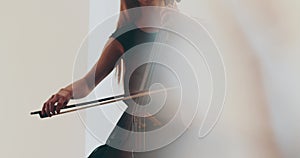 Single woman playing the cello, close-up and medium close-up, cello bow and strings