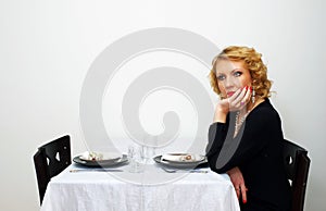 Single woman sits besides served table photo