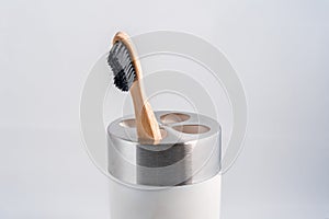 A single wooden eco-friendly toothbrush in a cup