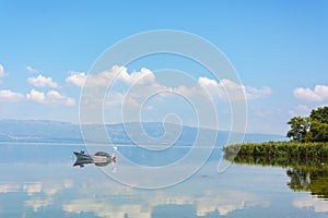 Single wooden Rowboat on Lake with Reflection in the Water