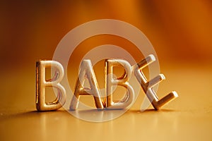 Single word `babe` in gold lettering