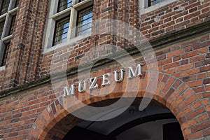 Single word MUZEUM on red brick wall. Sign muzeum on the museum building in Torun, Poland