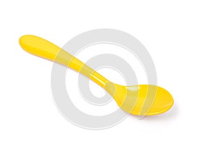 Single yellow plastic spoon