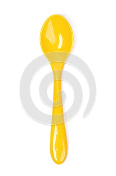 Single yellow plastic spoon isolated photo